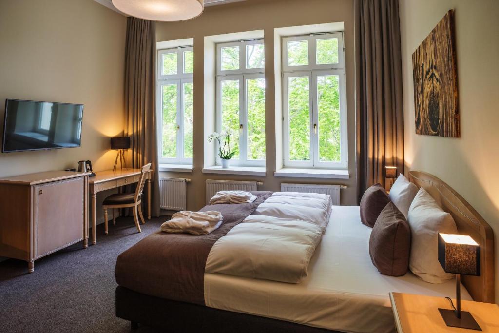 ヘリングスドルフにあるUpstalsboom Heringsdorfのベッドと机と窓のある寝室