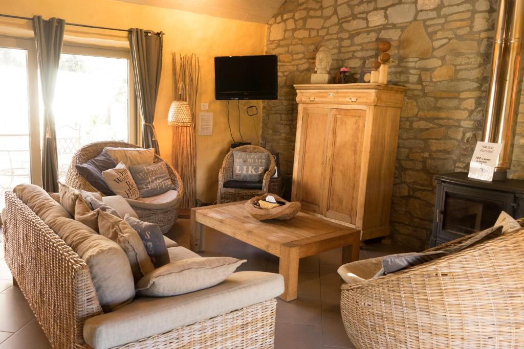 ein Wohnzimmer mit Korbstühlen und einer Steinmauer in der Unterkunft Gîte de Corbion in Leignon