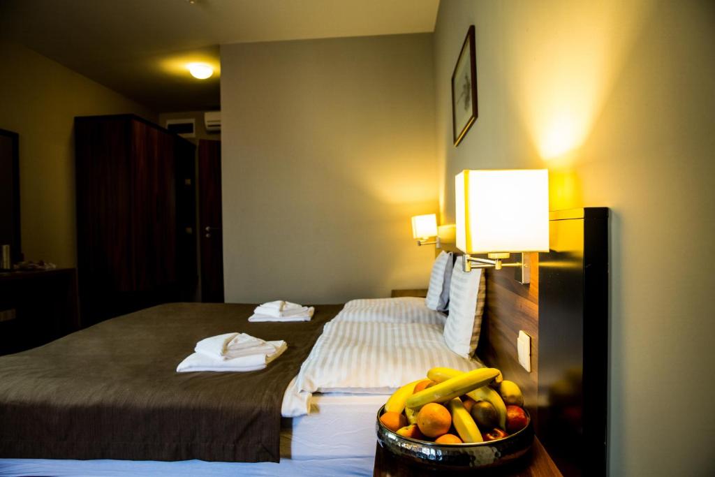 a hotel room with a bed and a bowl of fruit at Fiáker Panzió in Zalaszentgrót