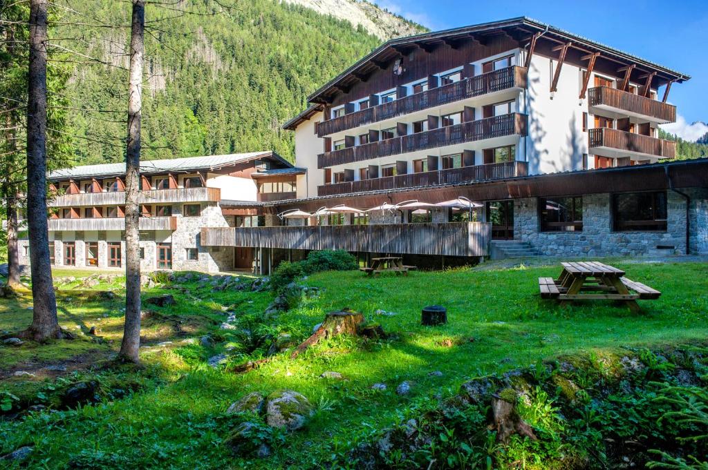 - un grand bâtiment avec une table de pique-nique devant dans l'établissement Chalet ATC Routes du Monde Argentiere-Chamonix, à Chamonix-Mont-Blanc