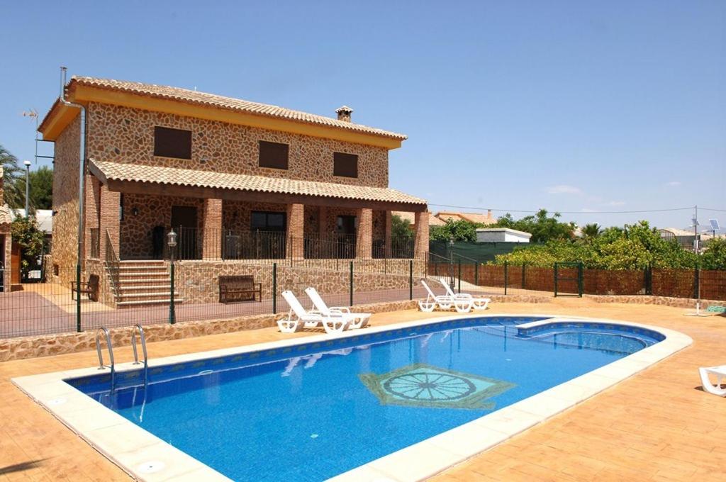 a swimming pool in front of a house at Casas Rurales El Viejo Establo in Fortuna