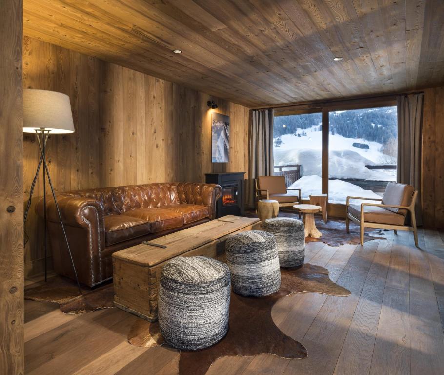 a living room with a leather couch and a table at La Résidence de L'Ours in Megève