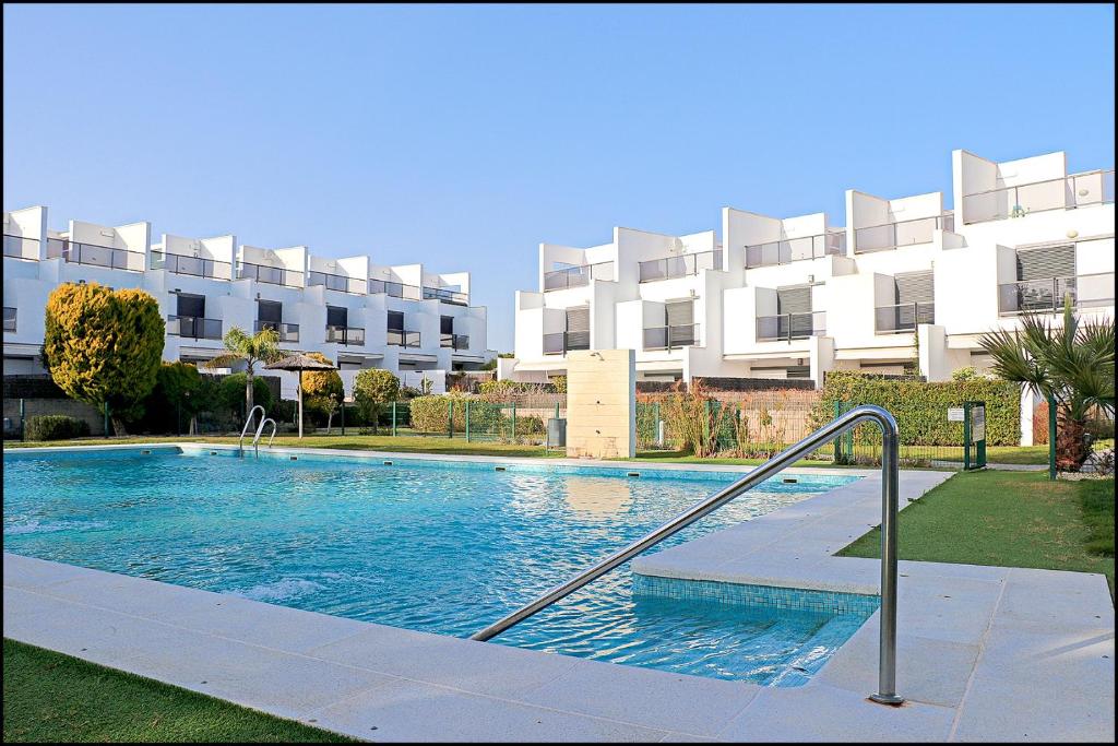 a large swimming pool in front of a building at Casa Residencial Playa Fontanilla in Conil de la Frontera