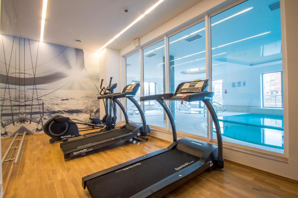 a gym with two treadmills and a treadmill at Fitness Apartment - Spa Sauna & Gym by Grand Apartments in Gdańsk