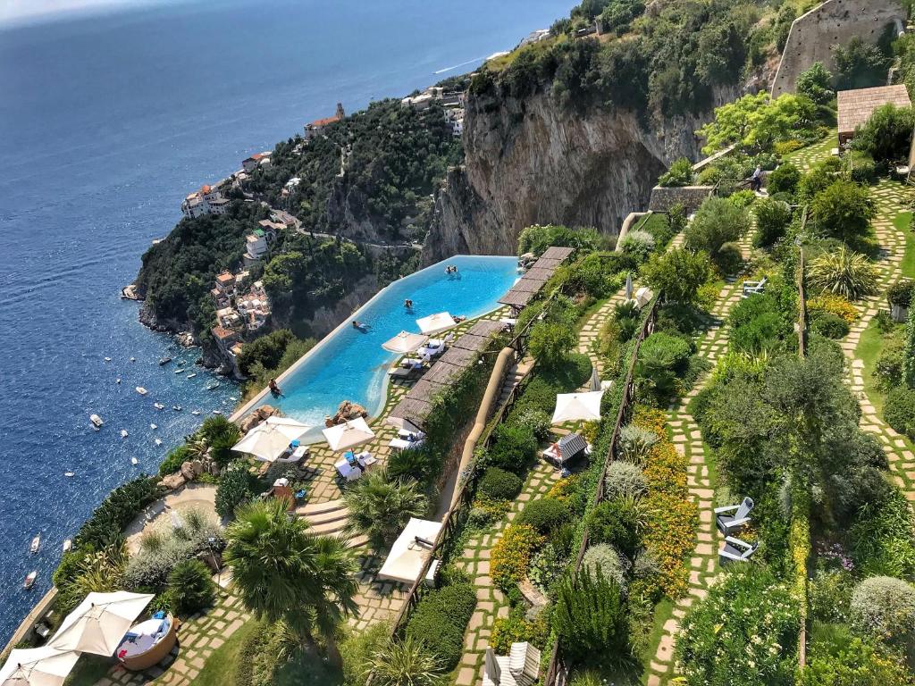 a beach filled with lots of palm trees at Monastero Santa Rosa Hotel & Spa in Conca dei Marini