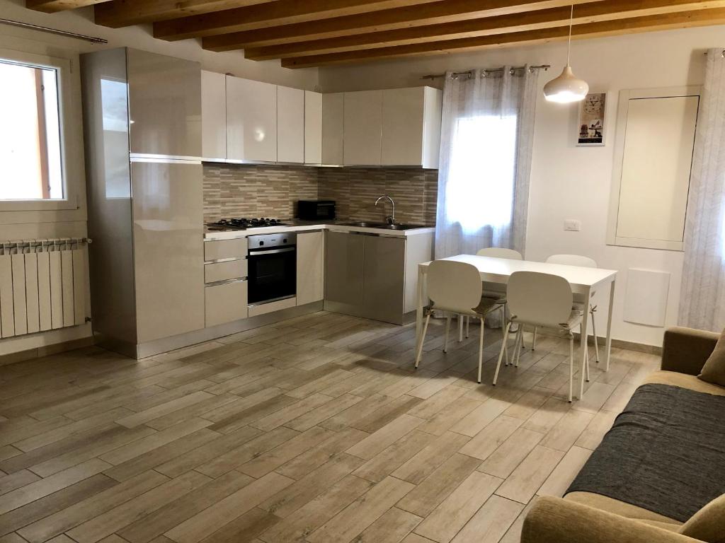 uma cozinha e sala de jantar com mesa e cadeiras em Casa Sophy em Chioggia