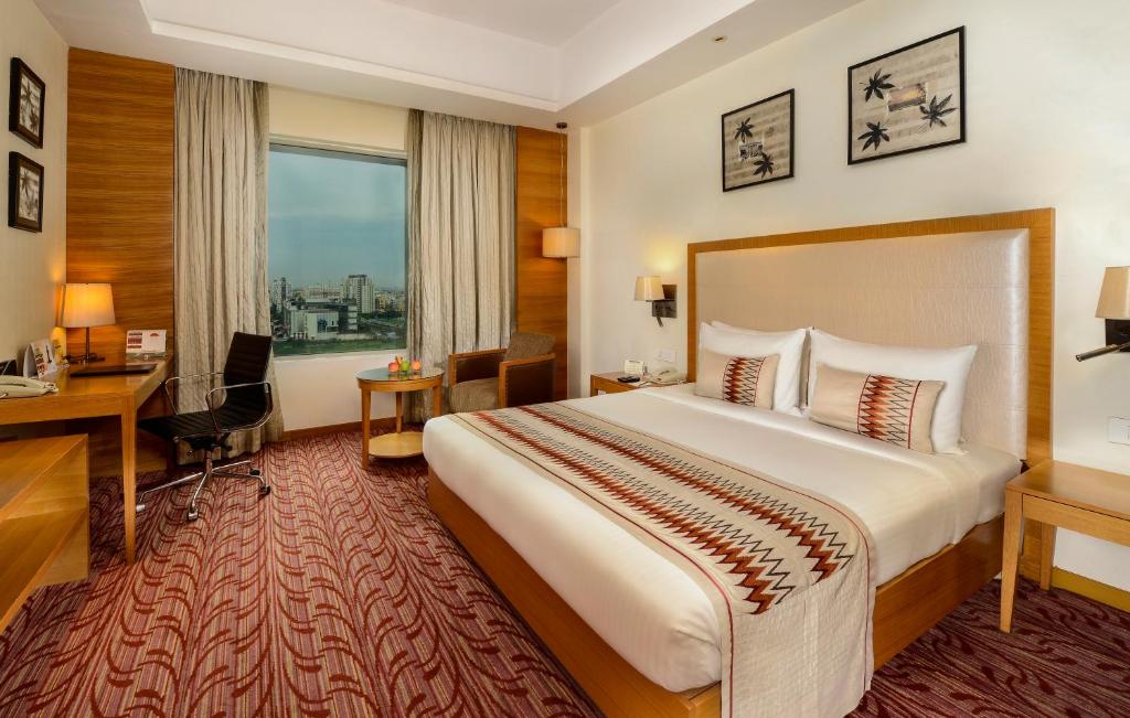 Postel nebo postele na pokoji v ubytování Pride Plaza Hotel, Kolkata