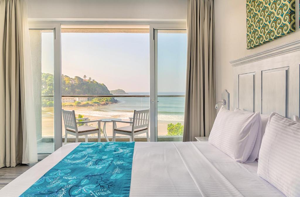 a bedroom with a bed and a view of the ocean at Blue Beach Galle in Galle