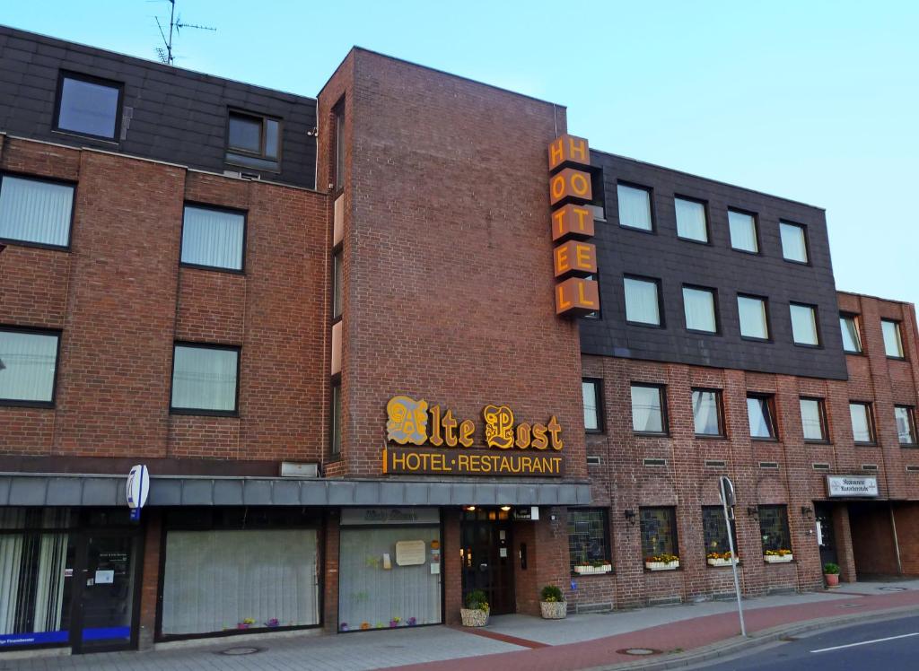 un edificio de ladrillo rojo con un cartel. en Hotel Alte Post, en Lehrte