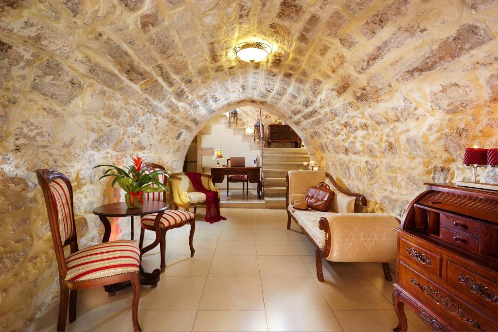 a living room with a stone wall at Archontiko Old Town Suites in Rethymno Town