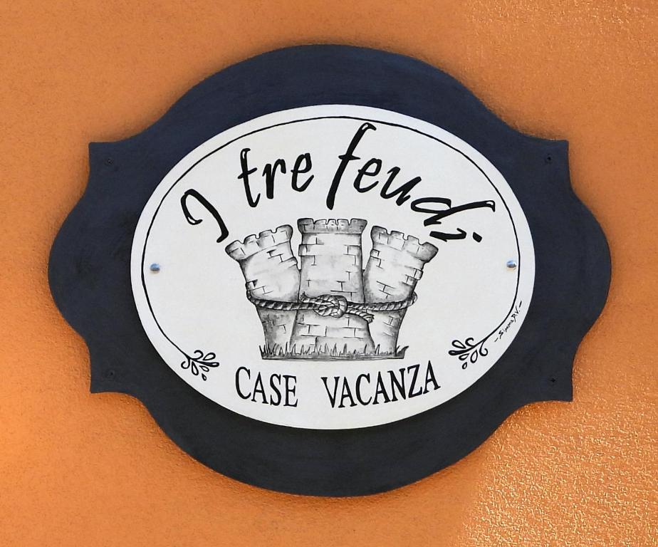 un cartello di fuoco su un muro con una torta di un fondo di alberi vazazona di I tre feudi - Casa Vacanza ad Avetrana