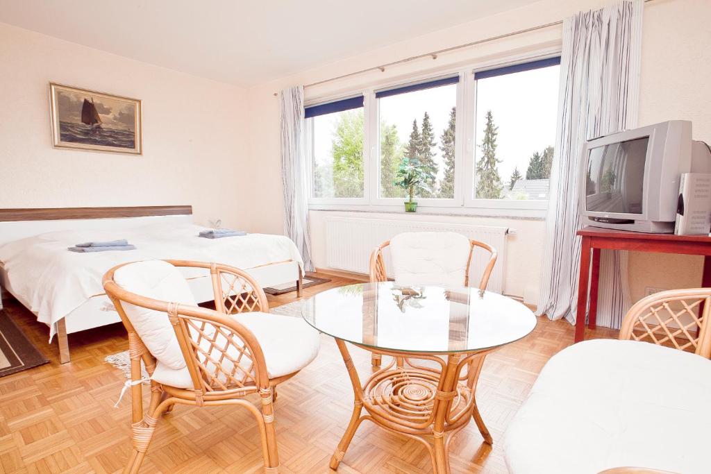 sala de estar con mesa, sillas y TV en Ferienhaus Seestern am Steinhuder Meer, 5 Schlafzimmer, en Steinhude