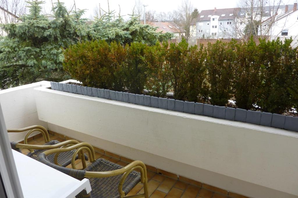a pair of chairs on a balcony with plants at A&M Wohnen-West in Ravensburg