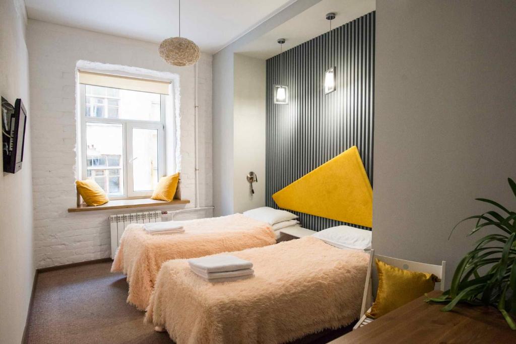 a bedroom with two beds and a window at Loft on Sadovaya in Saint Petersburg