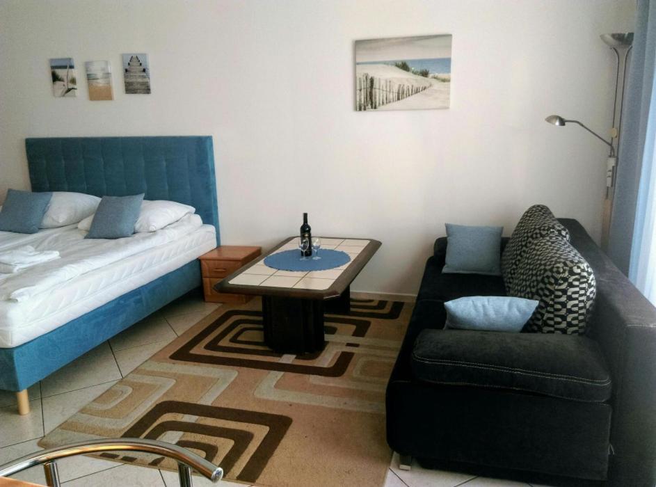 uma sala de estar com uma cama, uma mesa e um sofá em ApartamentyPrzyMorzu Reymonta em Kolobrzeg