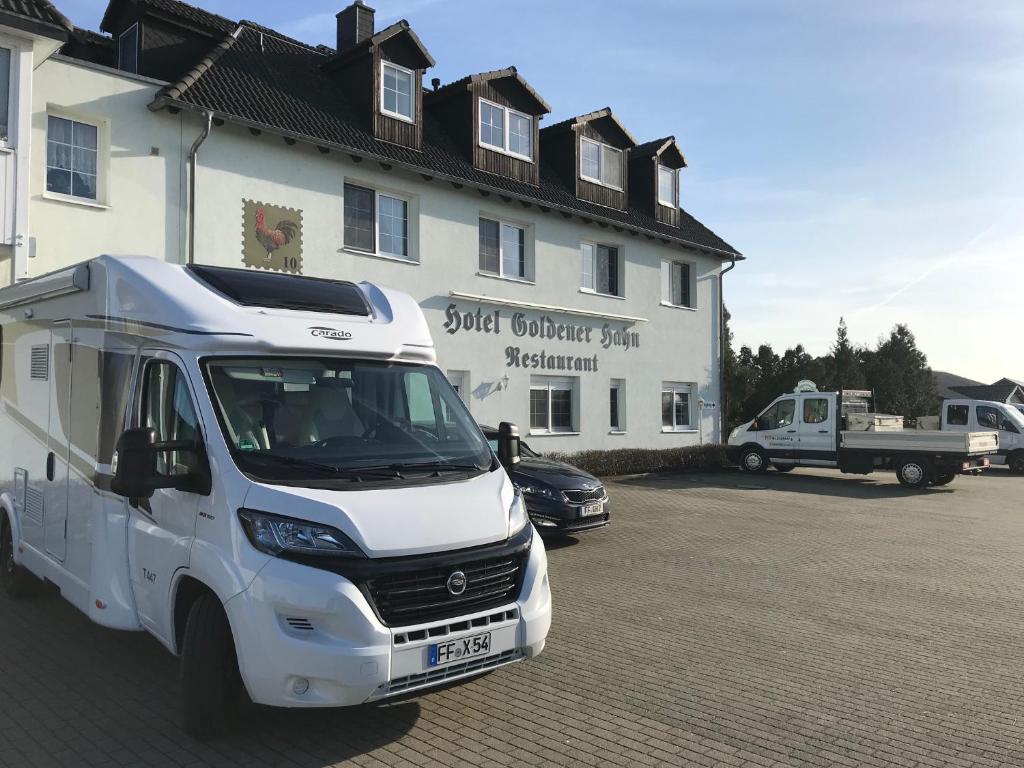 a white truck parked in front of a building at Hotel Gasthof Goldener Hahn in Frankfurt Oder