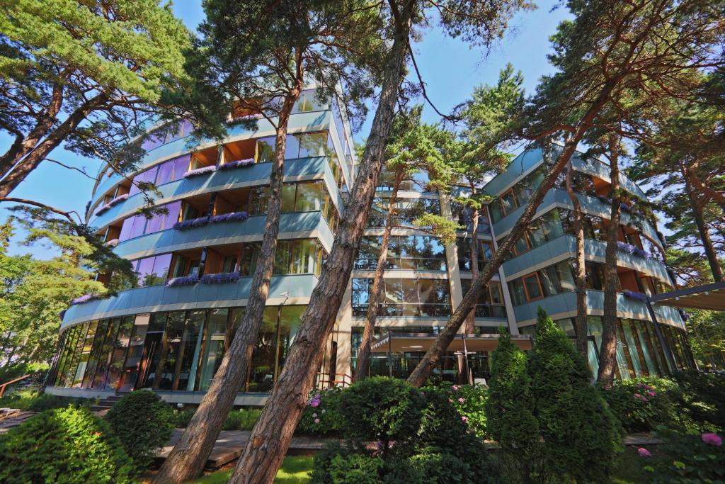 a building with trees in front of it at Palanga Life Balance SPA Hotel in Palanga