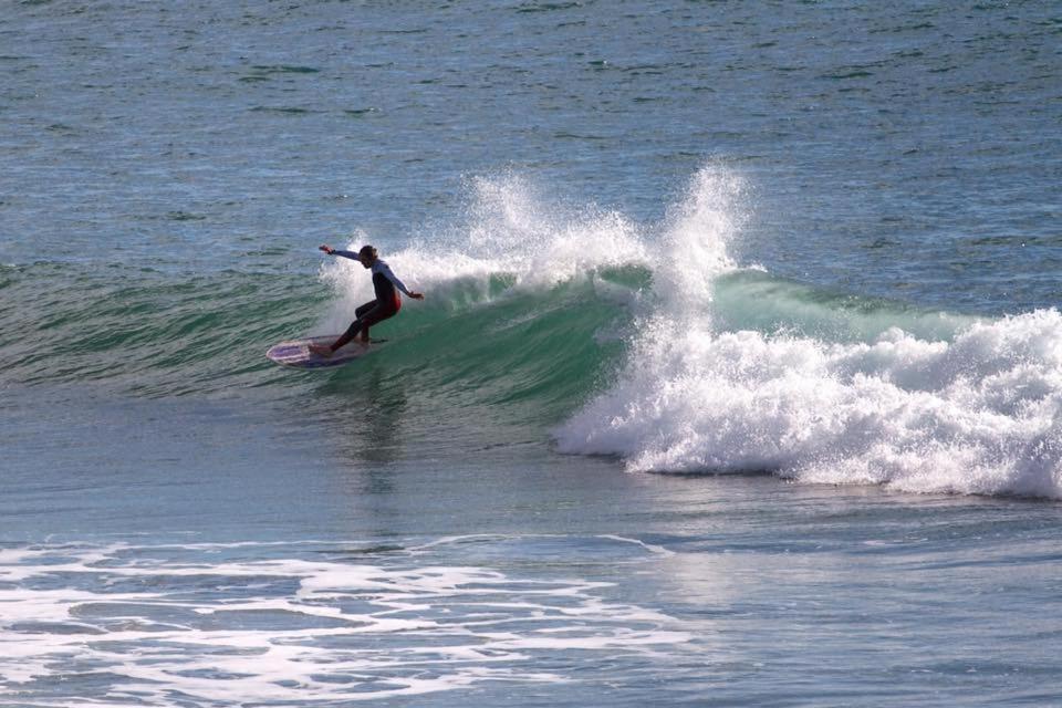 Ein Mann reitet eine Welle auf einem Surfbrett im Ozean in der Unterkunft Inchydoney Apt 6, Block D in Clonakilty