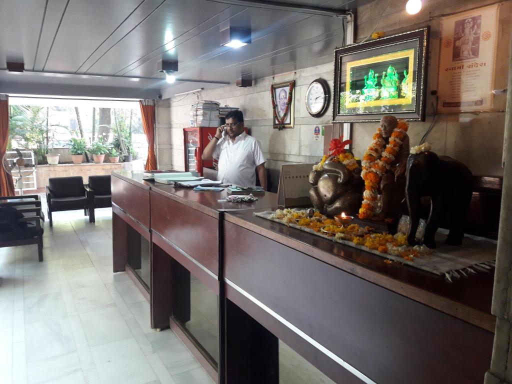 a man talking on a cell phone in a restaurant at Maurya Residency in Pune