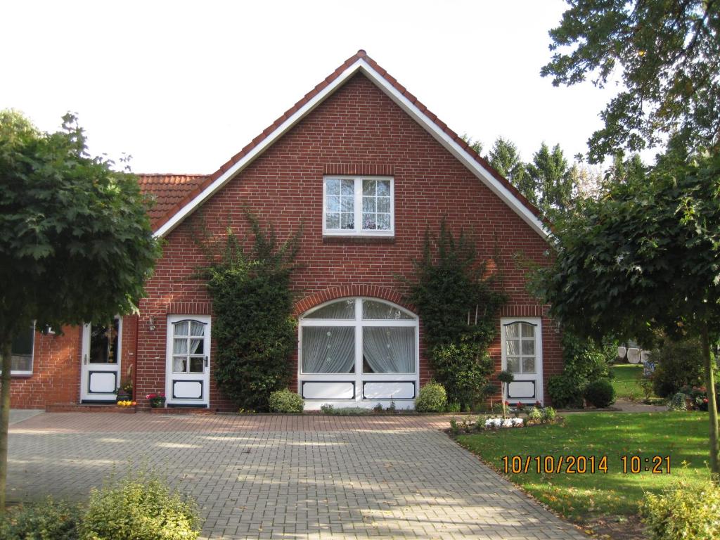 a red brick house with two windows and a driveway at Fewo Karin Tiedemann in Hechthausen
