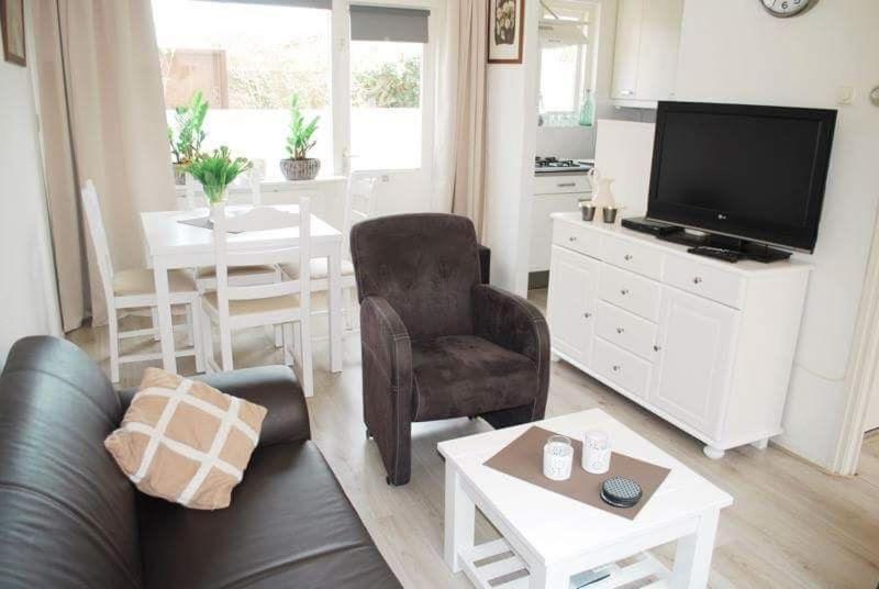 een woonkamer met een bank en een tafel bij Beach-house27 in Egmond aan Zee