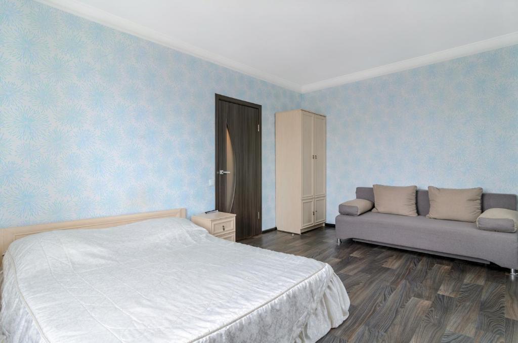ein Schlafzimmer mit einem Bett und einem Sofa in der Unterkunft The Modern Home пр М Лушпы 22 in Sumy