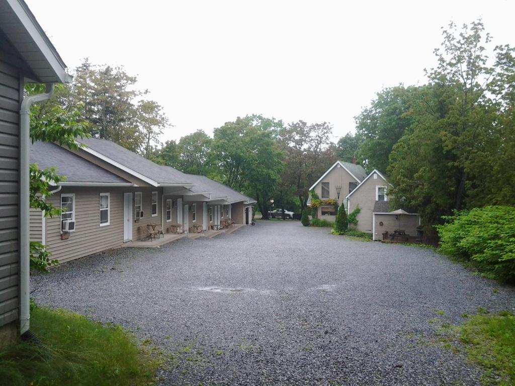 a gravel driveway between two houses and a building at Rothesay Motel in Rothesay
