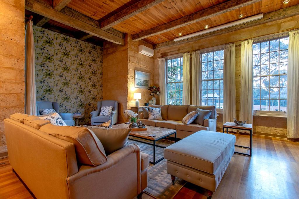 a living room with couches and chairs and windows at Birdwood Estate in Wilyabrup