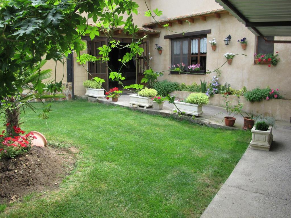 un patio con macetas y una casa en Albergue San Pelayo en Villarente