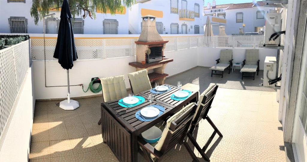 a patio with a table and chairs on a balcony at Apartamento Praia Altura - Terraço BBQ - Wifi - AC - Garagem Fechada in Altura