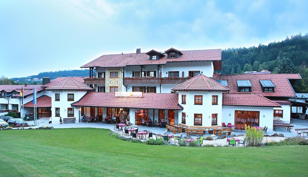 un gran edificio con un patio con mesas y sillas en Wellness- und Wohlfühlhotel Waldeck, en Bodenmais