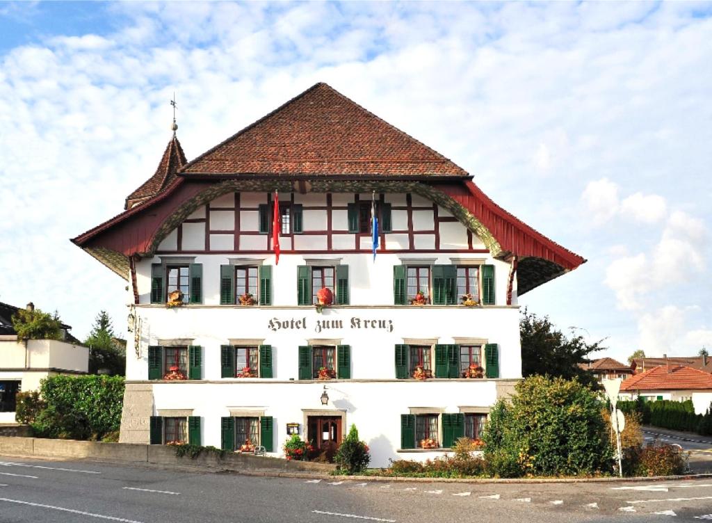 ein großes weißes Gebäude mit braunem Dach in der Unterkunft Hotel zum Kreuz in Suhr