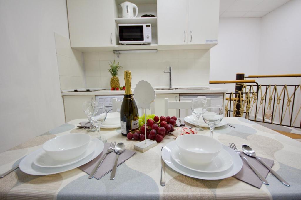 einen Esstisch mit weißen Tellern und Weingläsern in der Unterkunft Blue Point Apartment Ljubljana in Ljubljana