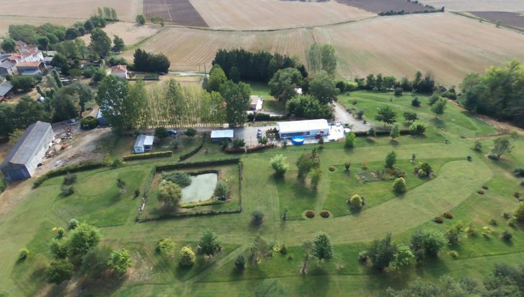 une vue aérienne sur un grand champ verdoyant planté d'arbres dans l'établissement Parc Des Oliviers, à Gaudiès