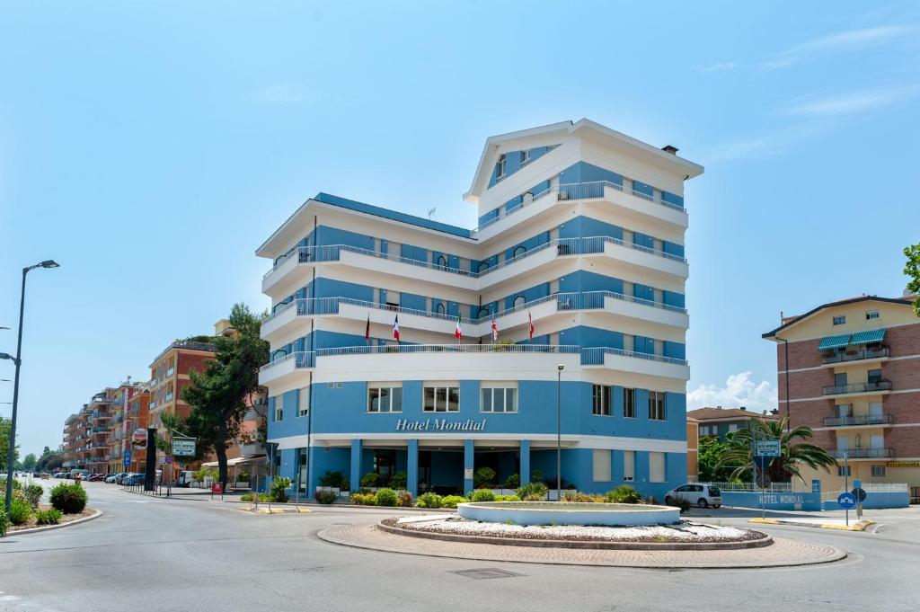 een groot blauw-wit gebouw in een straat bij Hotel Mondial in Porto Recanati
