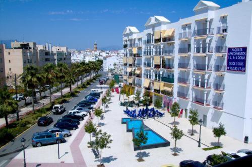 a city street with cars parked in a parking lot at Apartamentos Miguel Angel in Estepona