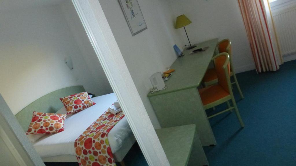 a room with a bed and a desk and a mirror at Les Balcons Du Velay in Monistrol-sur-Loire