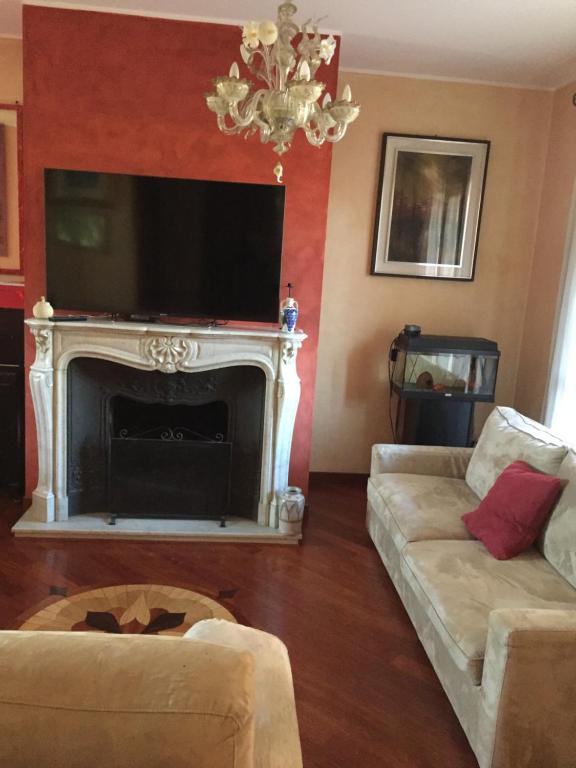 a living room with a fireplace and a tv at B&B Borgo dei Fiori in Rozzano