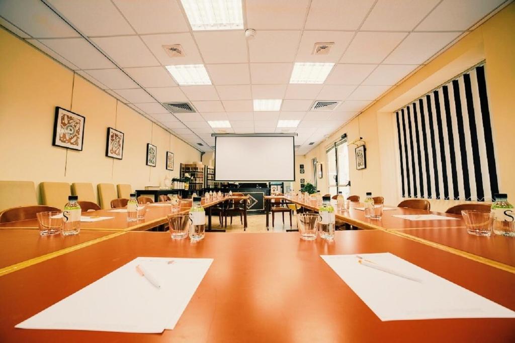 a large conference room with a long table and a screen at Napoleon in Ajaccio
