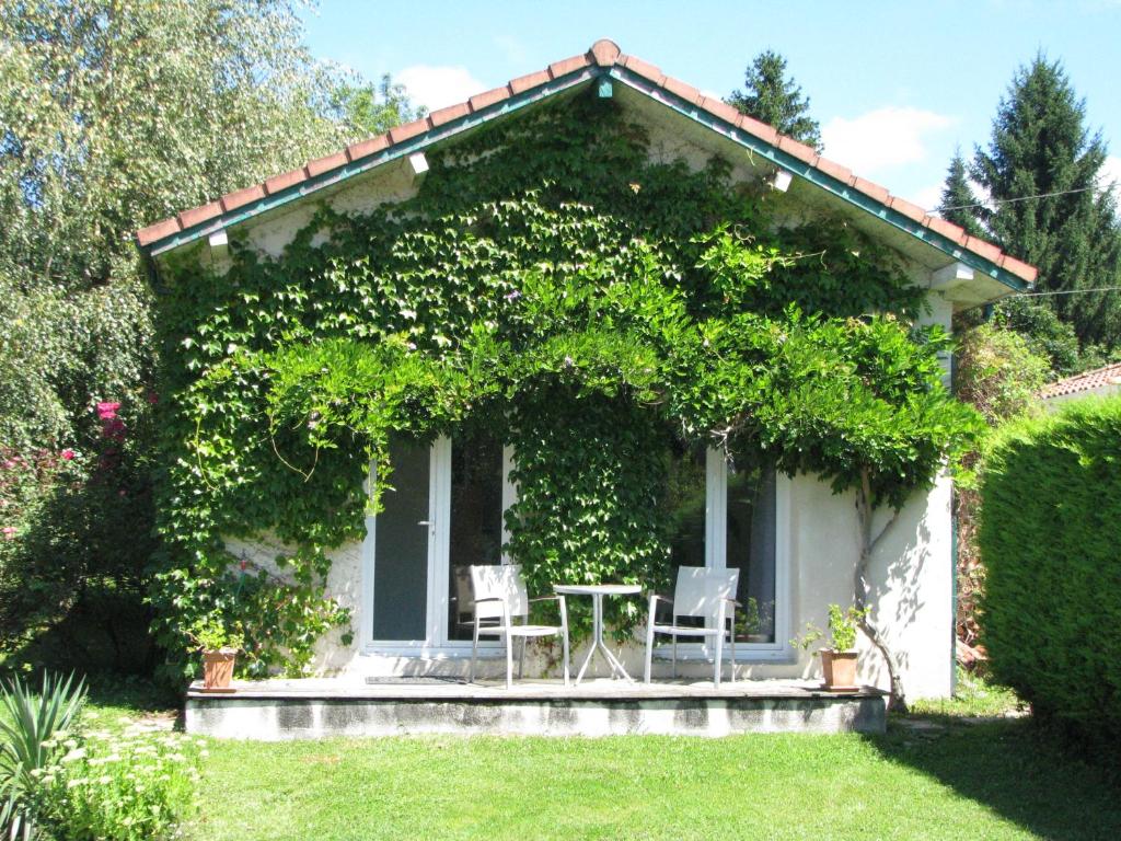 a small house with a table and chairs in a yard at LE NID DOUILLET in Ore