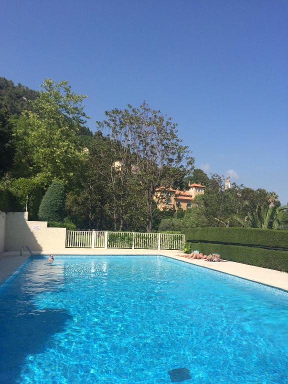 une grande piscine bleue avec une clôture blanche dans l'établissement Residence de Croisset Vue panoramique Cote d Azur, à Grasse