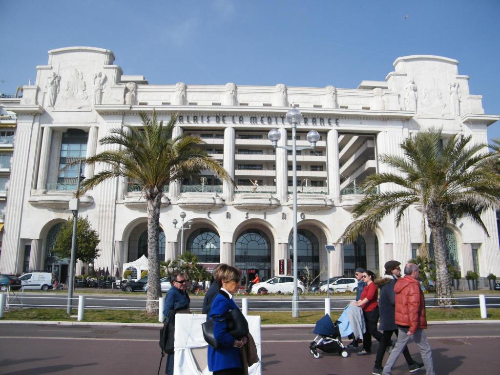 un groupe de personnes marchant devant un bâtiment dans l'établissement Residence du Palais Nil, à Nice