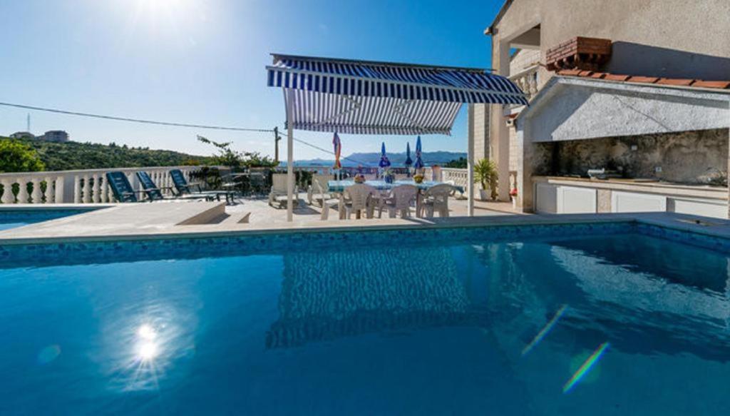 a swimming pool in front of a house at Villa Arka in Cavtat