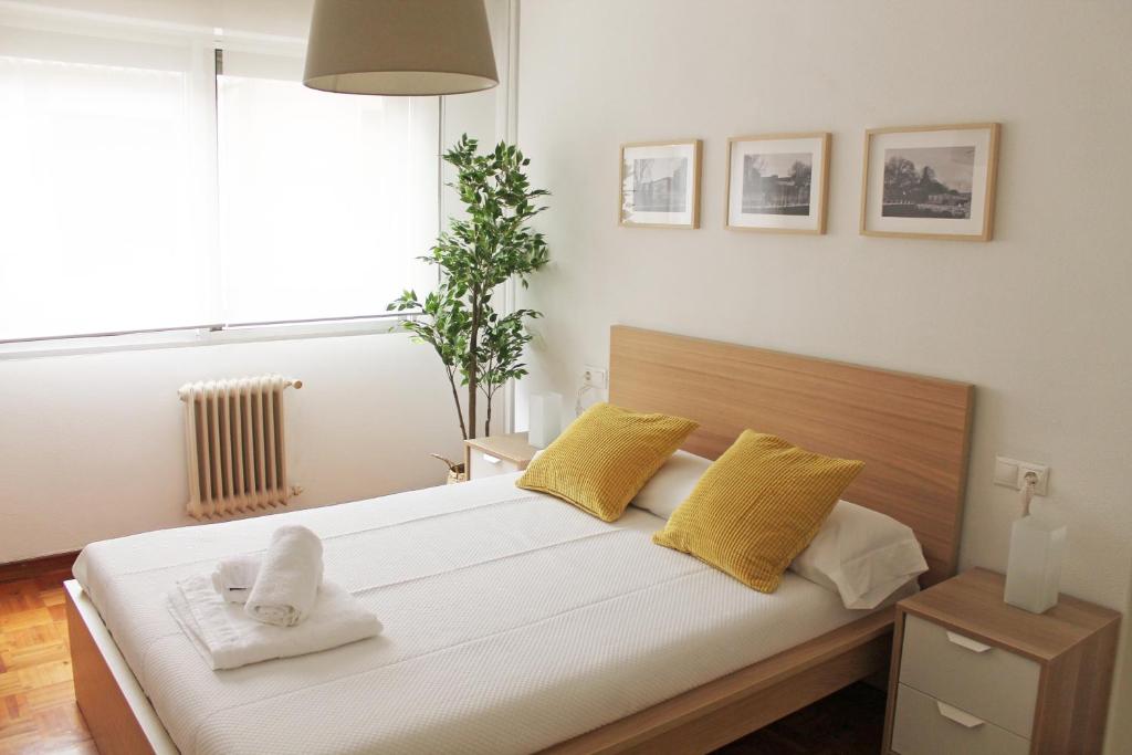 ビラガルシーア・デ・アロウサにあるApartamento Vilagarcía de Arousaのベッドルーム1室(黄色と白の枕付きのベッド1台付)