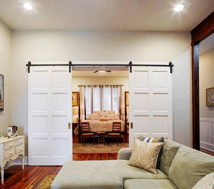 a living room with a couch and a sliding barn door at 414 Waldburg A · Newly Renovated Apt with outdoor space! in Savannah