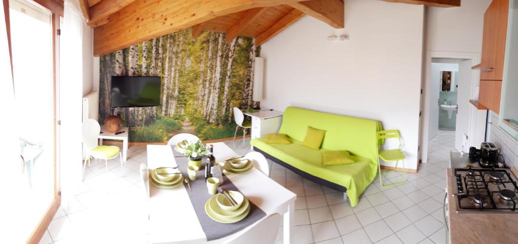 リーヴァ・デル・ガルダにあるAppartamento Betullaのリビングルーム(緑のソファ、テレビ付)