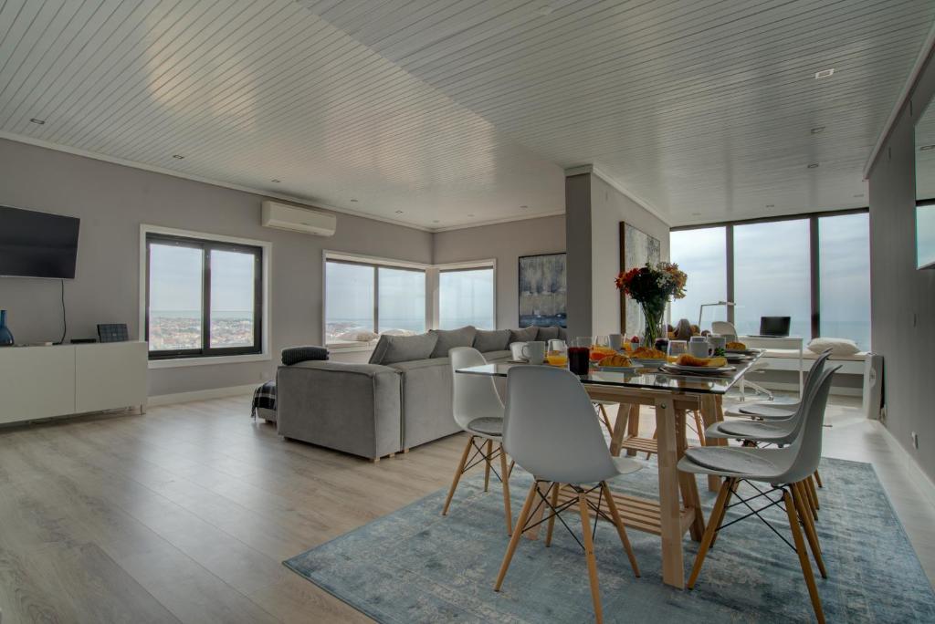ein Wohnzimmer mit einem Tisch, Stühlen und einem Sofa in der Unterkunft Ocean Blue Apartment & Studio in Monte Estoril