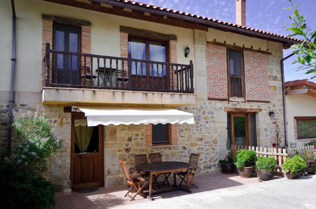 a house with a table and a balcony at Apartamentos Playa Galizano in Galizano