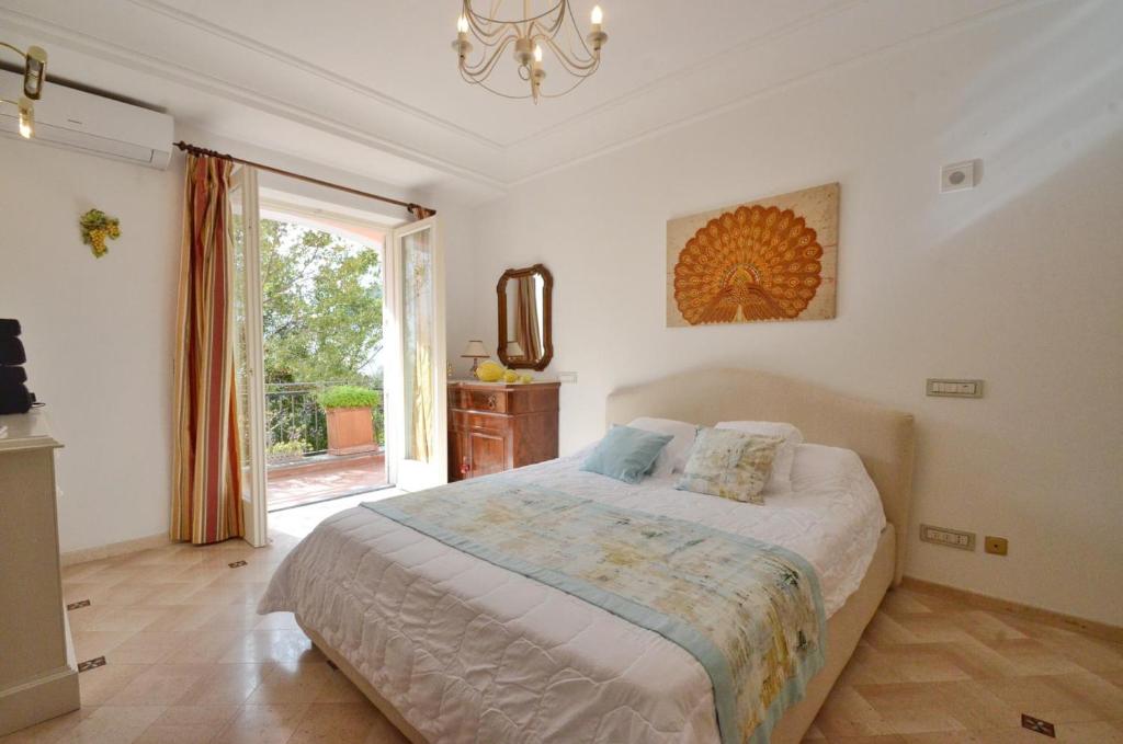 a bedroom with a bed and a large window at CASA GADEAMUS via le botteghe 12 in Capri