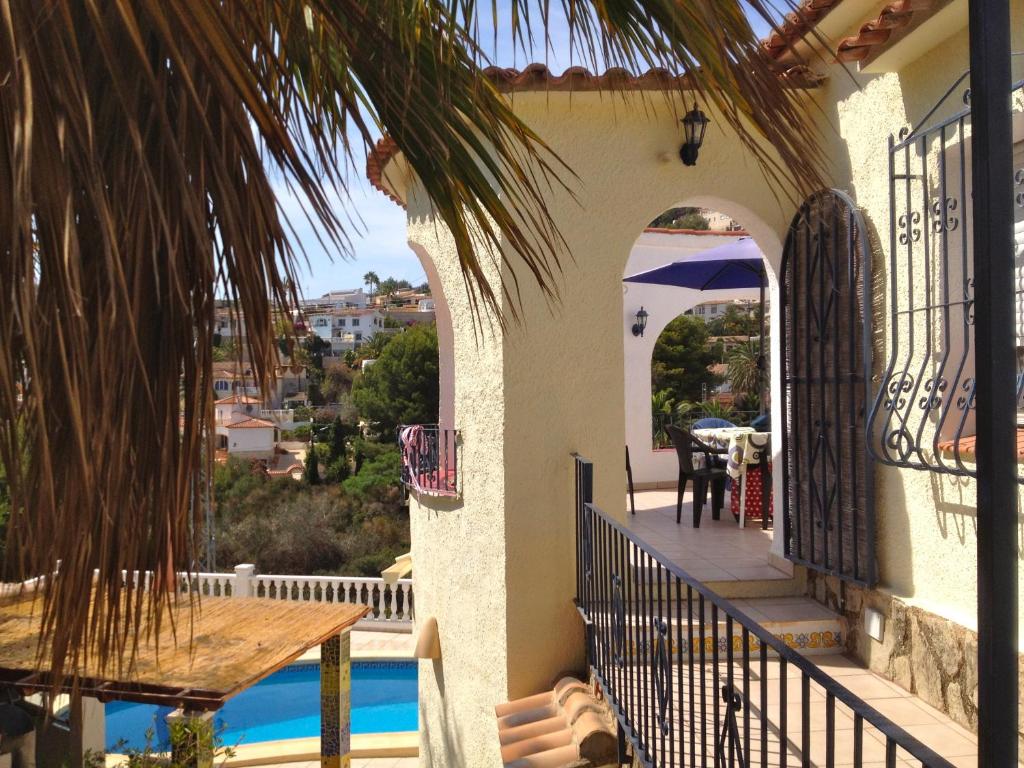 a house with a balcony with a table and a pool at Casa Pauline in Benissa